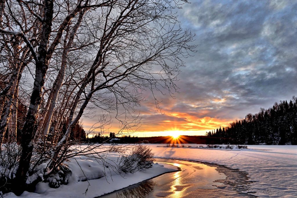 Solnedgång i vinterlandskap.