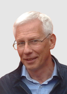 Profilbild på Gunnar Hägglund. Gunnar har vitt hår och bär glasögon, ljusblå skjorta och svart tröja.