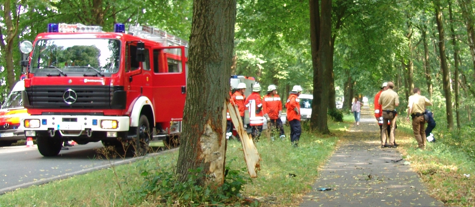 Olycka på gångväg. Ambulans, brandbil och räddningspersonal hjälper till.