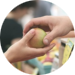 Hand som ger annan hand ett äpple.